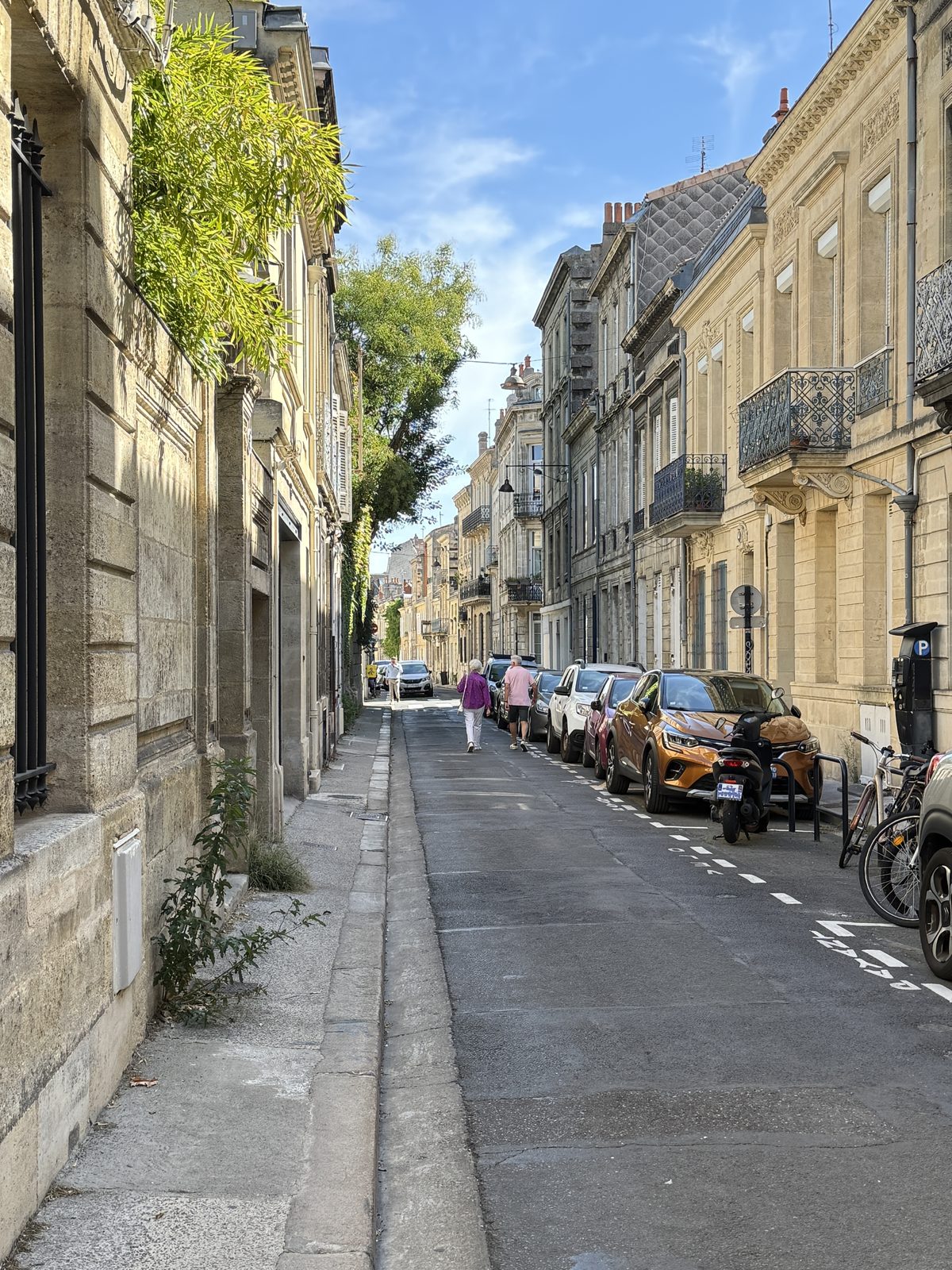 Liz and Beth walking a quiet Bordeaux side street in the morning light.