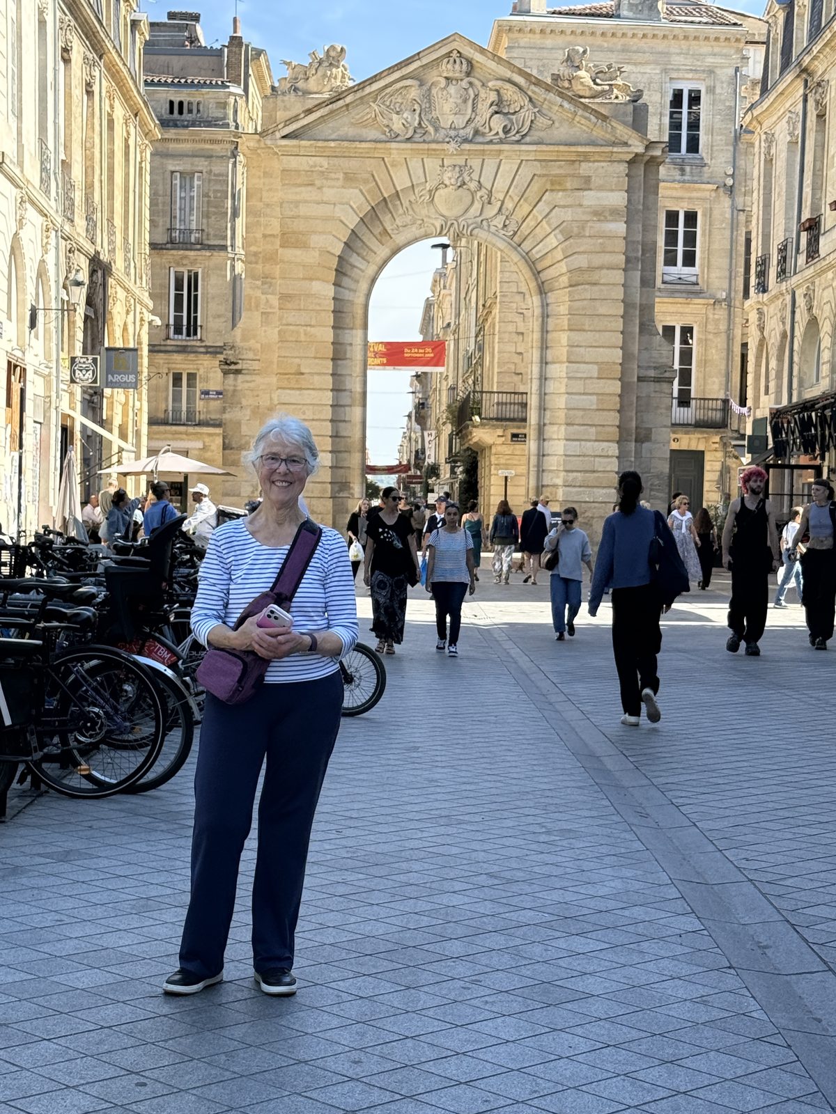 Beth standing proud in front of the Porte Dijeaux, one of Bordeaux's monumental 18th-century gates.