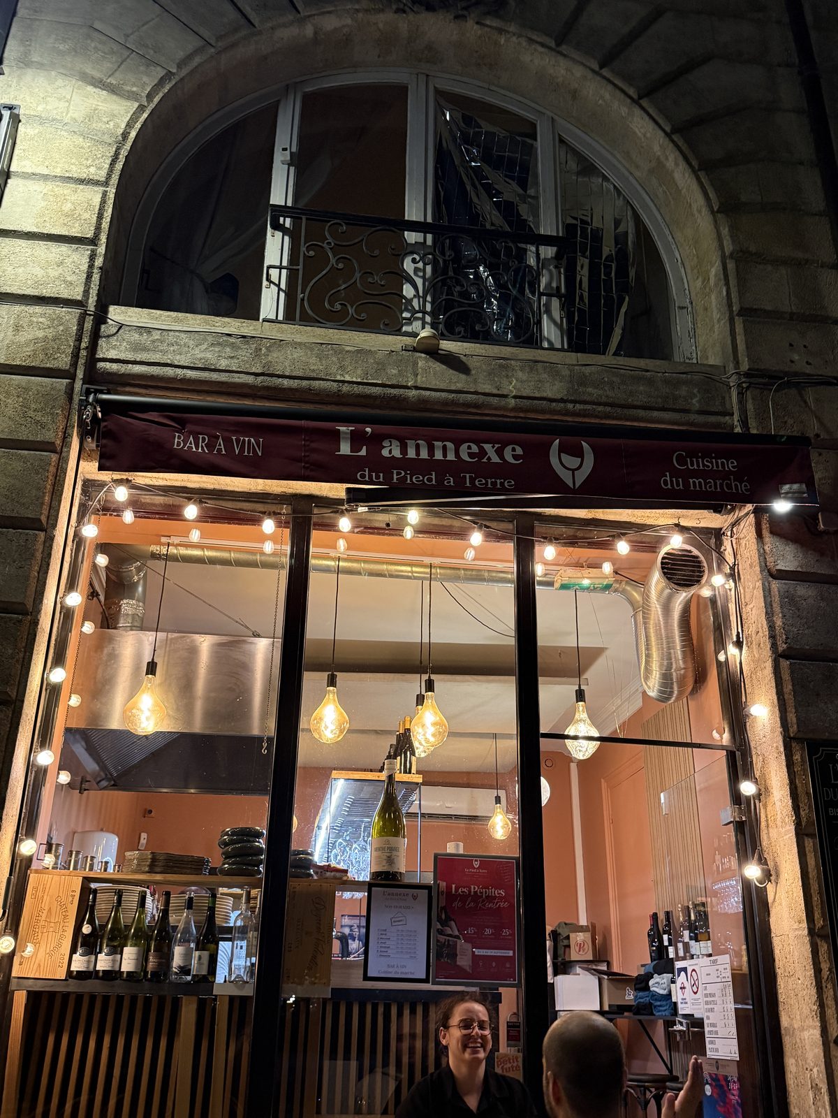 L'Annexe du Pied à Terre, the wine bar where Liz and Beth had dinner, all lit up after dark with its signature Edison bulb glow.